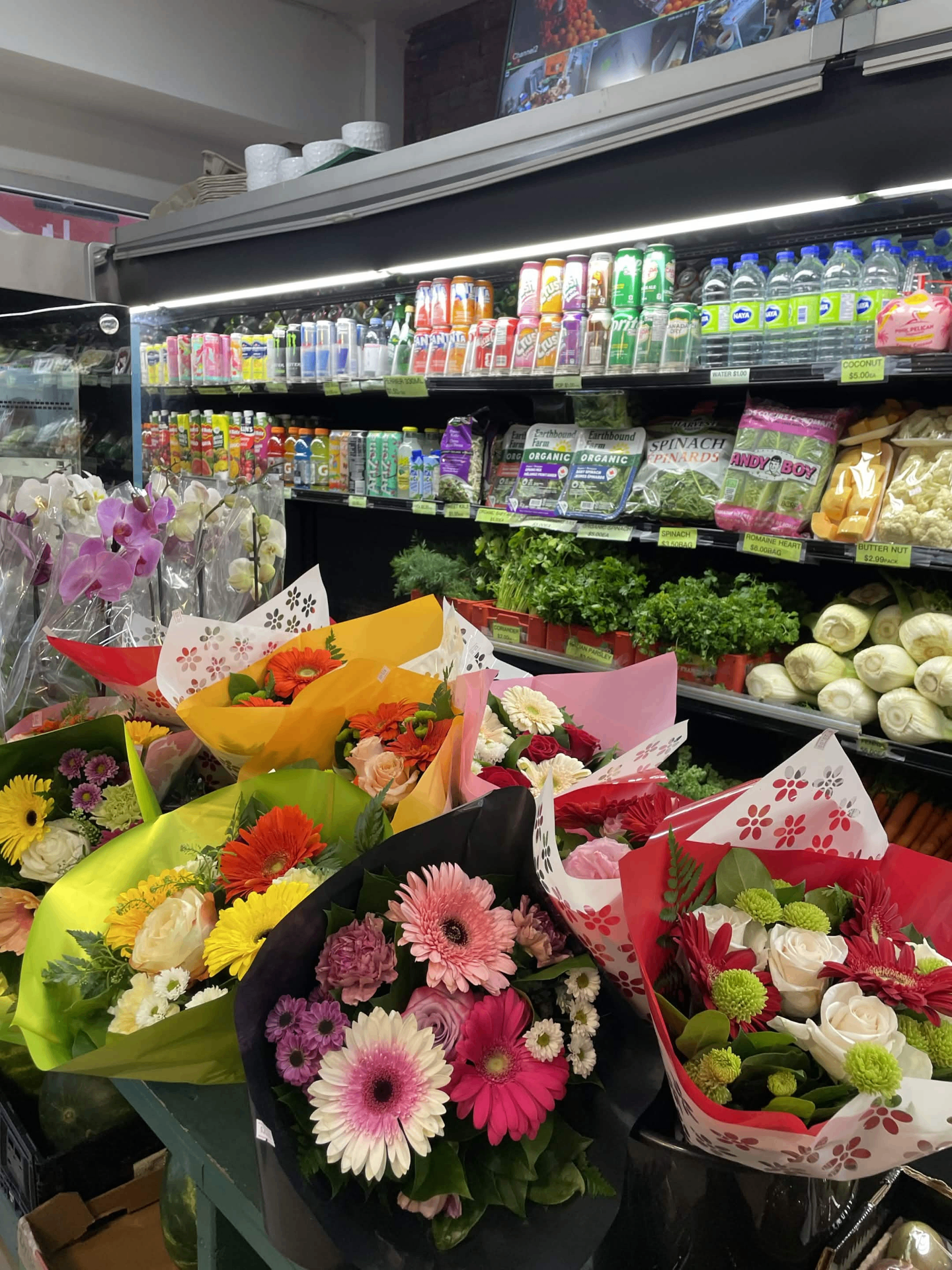 Fresh bouquets and orchids beside the produce coolers inside Fruitland Market